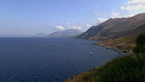 Aerial-panoramic-view-of-Sicilian-Riserva-dello-Zingaro-natural-reserve-in-Sicily-with-mountains-cliffs-boat-and-coves