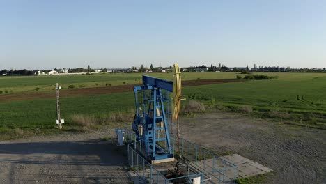 Luftaufnahme:-Ölpumpe-Bei-Sonnenuntergang-Auf-Dem-Land,-Alte-Stahlrolle,-Die-Öl-Fördert