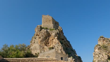 Tilt-up-of-typical-Tonnara-of-Scopello-hotel-in-Sicily-and-old-historical-watchtower-perched-on-stack,-Italy