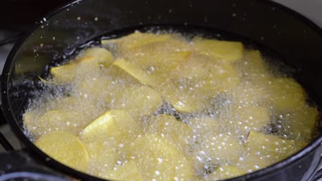 Close-Up-Of-Bubbling-Cooking-Oil-In-A-Pan-Frying-Sweet-Potato-Chips
