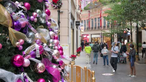 In-Hongkong-Machen-Menschen-Fotos-Von-Einem-Weihnachtsbaum,-Der-Mit-Verschiedenen-Glänzenden-Ornamenten-Wie-Bunten-Kugeln-Und-Schleifen-Geschmückt-Ist