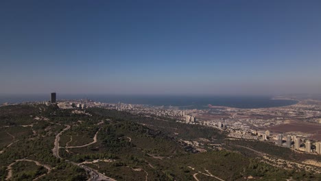 Vista-Estática-De-Una-Concurrida-Carretera-Cerca-De-Una-Ciudad-Costera-Con-Rascacielos-En-Un-Día-Soleado,-Haifa,-Israel
