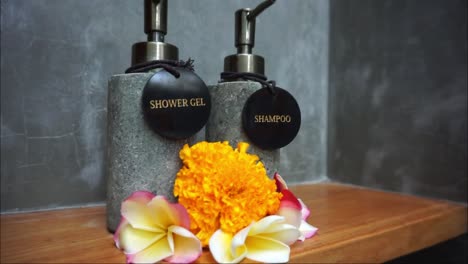 shampoo-bottle-and-shower-gel-with-beautiful-frangipani-flower-in-bathroom-HD-video