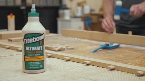 Carpenter-applying-Titebond-glue-to-dominos-making-furniture