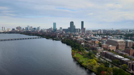 Aerial-view-over-river,-away-from-Boston-city-skyline,-USA---pull-back,-drone-shot