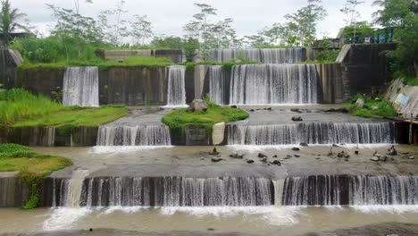Aerial-backwards-view-over-Watu-Purbo-waterfall-in-Muntilan,-Indonesia