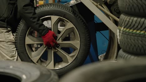 Close-up-of-a-wheel-that-is-mounted-by-operator-on-a-machine-for-balancing-and-toe-in