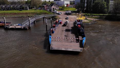 Vehículos-Saliendo-En-Servicio-De-Ferry-En-El-Río-De-Lek-En-Kinderdijk,-Países-Bajos