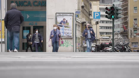 People-Wearing-Face-Mask-Walking-Across-The-City-Road-Of-Genoa,-Italy