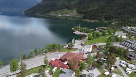 Luftaufnahme-Von-Der-Stadt-Kinsarvik-Norwegen-Mit-Hardangerfjord-An-Einem-Sonnigen-Tag-Und-Der-Fähre,-Die-In-Der-Ferne-Ankommt