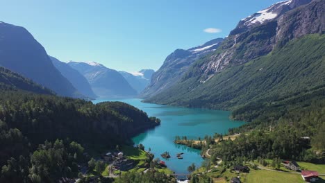 Spectacular-view-of-Loen-turquoise-glacier-water-among-epic-mountain-scenery-with-deep-valley-and-snow-capped-mountains---Reverse-aerial-Loen-Nordfjord-Norway
