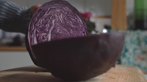 Close-up-woman's-hand-start-slicing-red-cabbage-with-a-sharp-knife-in-the-kitchen