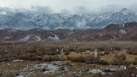 Montañas-Cubiertas-De-Nieve-Y-Paisajes-Pantanosos-Durante-Las-Nevadas,-Vista-Aérea-Ascendente