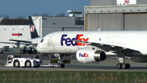 A-Fedex-Cargo-Boeing-757-Being-Towed-by-a-Tow-Truck,-Vancouver-Airport