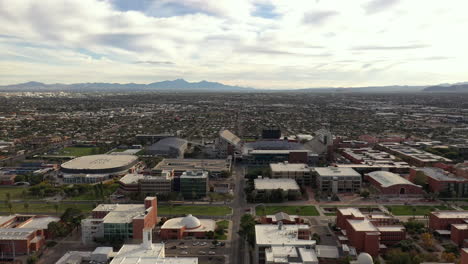 Flyover-University-of-Arizona-Tucson-campus-towards-Wildcat-stadium-with-city-aerial-view