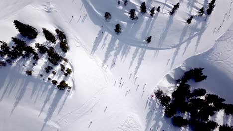 Vista-Aérea-De-Personas-Esquiando-Y-Haciendo-Snowboard-En-La-Colina,-Estación-De-Esquí