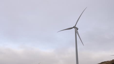 Wind-turbine-rotating-in-front-of-overcast-sky-generating-renewable-electricity
