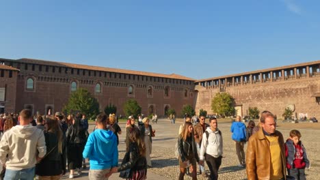 Crowd-of-people-walking-in-main-courtyard-of-famous-Sforza-Castle-in-Milan,-Italy