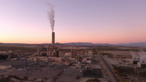 Willcox-Arizona-power-plant-with-white-smoke-out-of-chimney,-aerial-4k