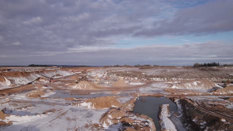 Drone-Flyover-Open-Mining-Pit,-Mining-Machines,-Gravel-Pit-in-Europe---Dolly-In-Shot