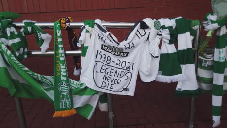 Wide-shot-of-tributes-being-left-at-Celtic-Park-stadium-for-Bertie-Auld