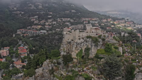 Eze-France-Aerial-v24-breathtaking-view-circular-pan-around-hilltop-medieval-fort-and-exotic-botanical-garden-overlooking-mountainous-landscape-and-mediterranean-sea---July-2021