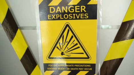 Danger-hazard-explosion-warning-safety-sign-with-yellow-precaution-ribbon-hanging-on-door