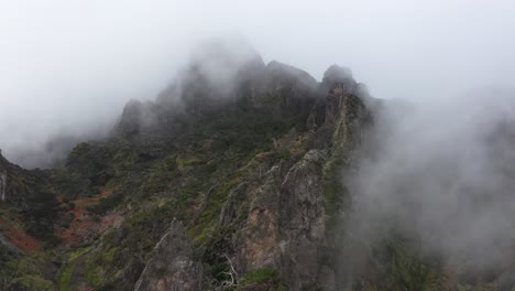 Luftaufnahme-Des-Nonnentals-Auf-Madeira,-Die-Sich-Rückwärts-Bewegt-Und-Mehr-Von-Dem-Dramatischen-Berg-Mit-Seinen-Gruseligen-Wolken-Zeigt