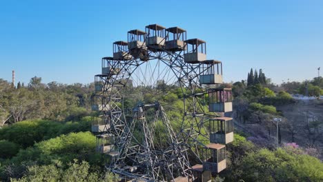 Aerial-close-up-pan-shot-around-idle-vintage-iron-Rueda-Eiffel-ferris-wheel-at-Sarmiento-park,-Cordoba,-Argentina