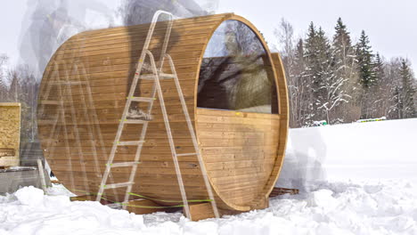 Gente-Construyendo-Sauna-De-Barril-De-Madera-Durante-El-Invierno