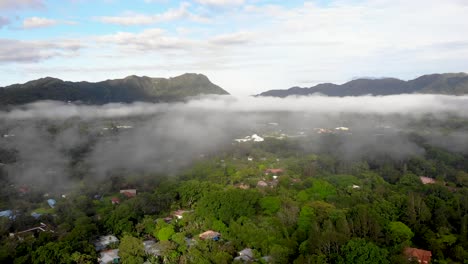 Low-clouds-over-Valle-de-Anton-town-in-central-Panama-located-inside-extinct-volcano-crater,-Aerial-dolly-left-shot