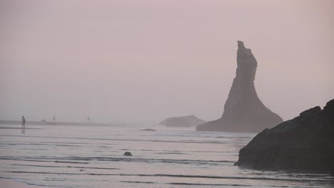 A-photographer-captures-a-picture-of-rock-stacks-in-the-mist-of-an-Oregon-beach