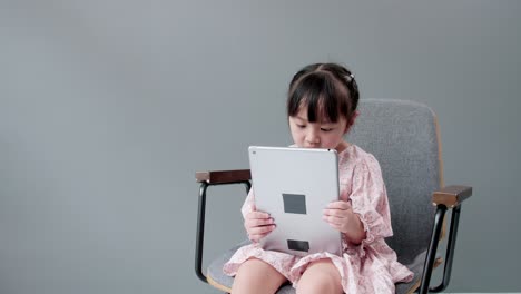 Child-watching-digital-tablet-and-looking-at-cheerful-camera