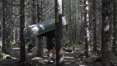 Slow-motion.-Man-portaging-canoe-through-forest
