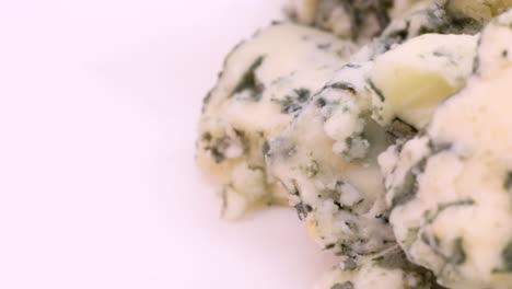 Chopped-blue-cheese-pieces-in-extreme-close-up-view,-macro-shot-in-4k-on-the-roght-side-of-the-frame