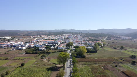 Aerial-drone-flight-towards-the-hills-with-view-of-city-in-Aljezur,-Algarve,-Portugal