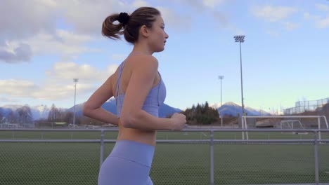 Slowmo-Profile-Follow-Shot,-Athletic-Woman-Jogs-on-Track-Facing-Right
