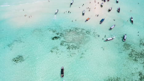 Motorboats-cruising-around-shallow-tropical-sandbank-with-people