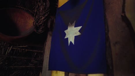 Hand-Einer-Blauen-Guñelve-Mapuche-Flagge,-Die-An-Der-Innenwand-Eines-Traditionellen-Ruka-Aborigine-Hauses-In-Chile-Hängt
