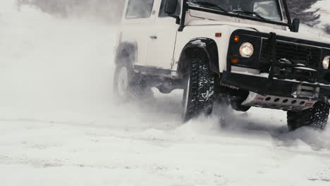 Epische-Aufnahme-Des-Land-Rover-Defender-D90,-Der-In-Einer-Harten-Kurve-Auf-Einer-Verschneiten-Hinterlandstraße-Driftet
