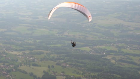 Paraglider-taking-off-the-side-of-a-grass-covered-mountain