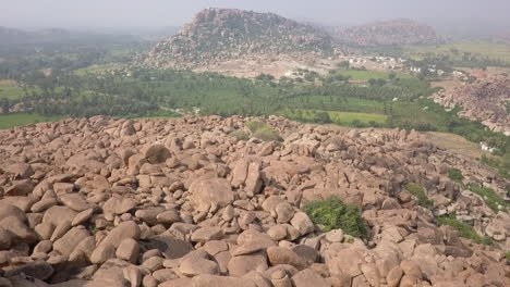 Lone-man-is-lost-among-the-giant-stacks-of-huge-stones-in-Hampi,-India