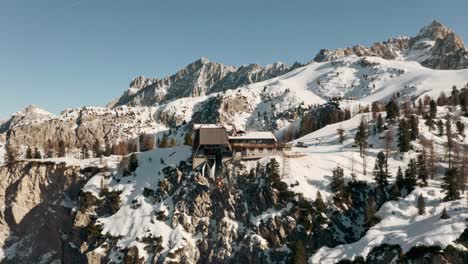Circling-drone-shot-of-gondola-arriving-at-mountain-ski-Chalet-Swiss-alps