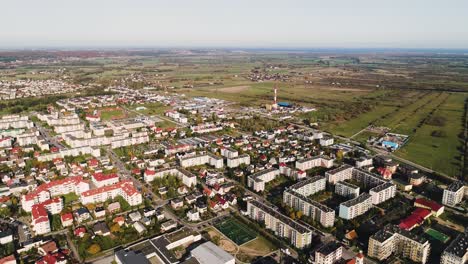 North-of-Poland,-aerial-view-of-little-rural-village-in-the-countryside-with-condo-residential-house-flat-and-5g-tower,-European-industrial-development