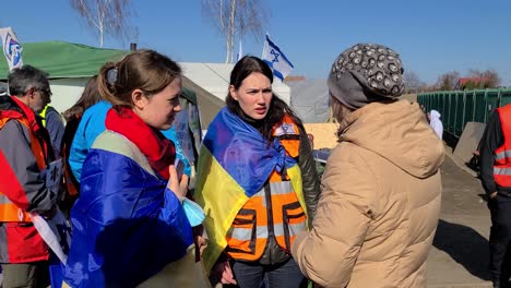 Volunteers-Help-A-Ukrainian-Woman-At-A-Refugee-Camp-On-Border-of-Poland
