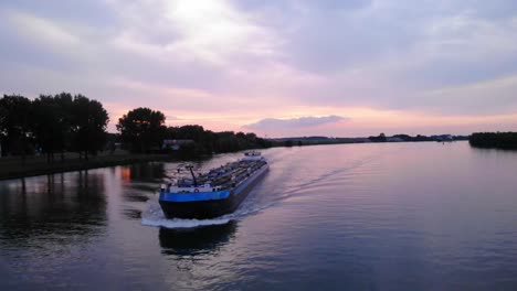 Inland-Motor-Tanker-Navigating-Oude-Maas-Against-Sunset-Skies-Near-Puttershoek