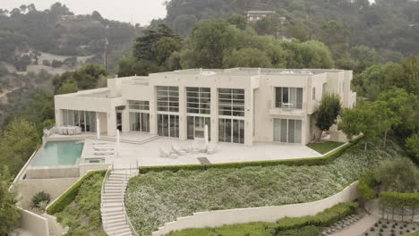Aerial-pull-in-on-a-Beverly-Hills-mansion-on-a-smokey-day