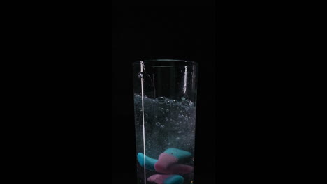 Candy-falling-into-fizzy-water-closeup-in-slowmotion