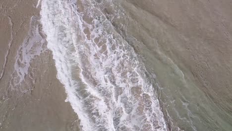 Luftaufnahme-Aus-Der-Vogelperspektive-über-Den-Wunderschönen-Türkisfarbenen-Meereswellen,-Die-Den-Strand-Umspülen