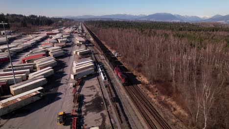 Aerial-view-of-cargo-train-running-on-railway-along-Vancouver-shipping-terminal-in-Canada